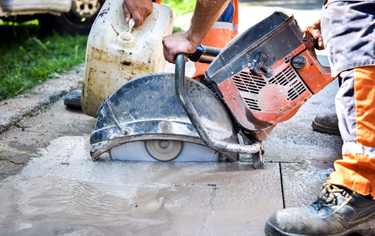 Professional concrete contractor using a machine to repair uneven concrete.