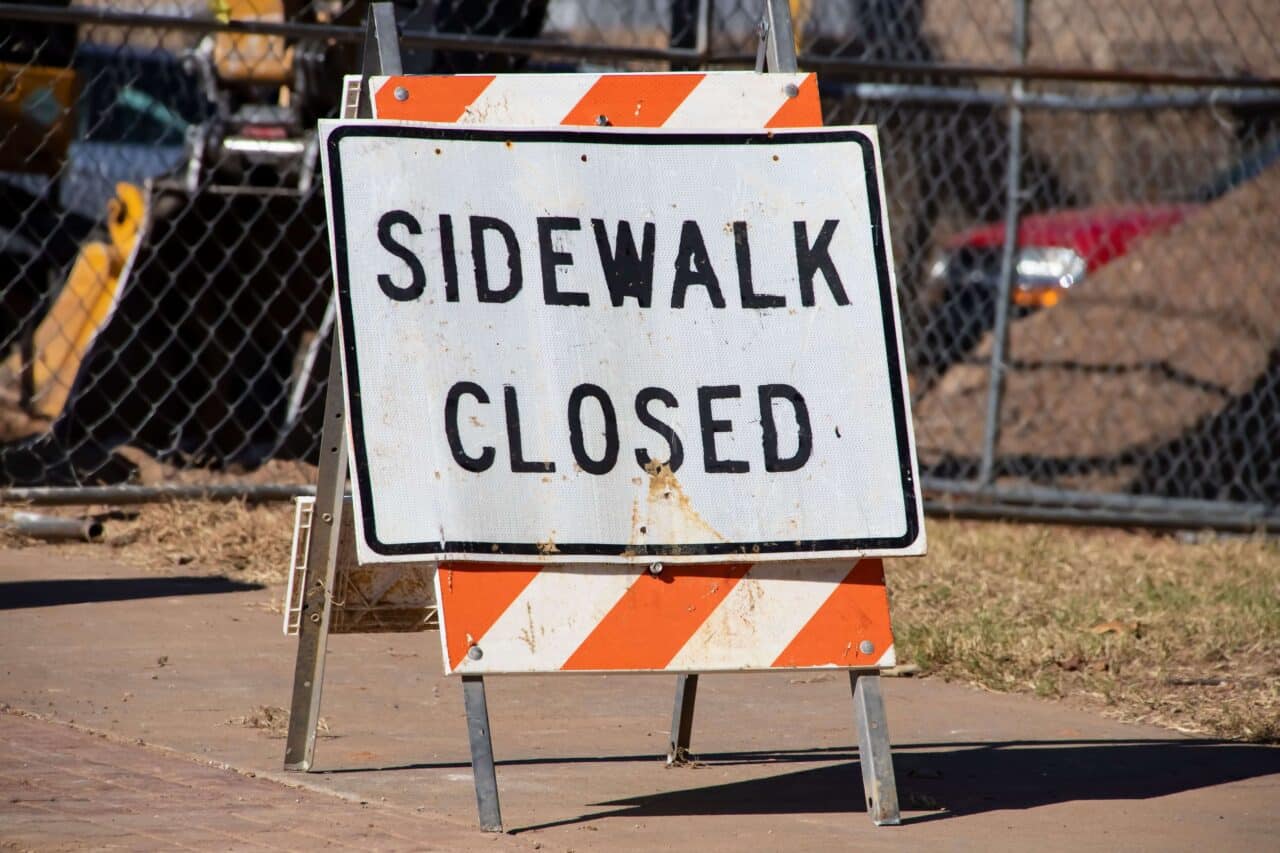 Hazard sign that says "sidewalk closed".